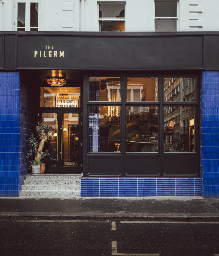 Pilgrm Hotel entrance. 25 London Street. Workshop Coffee. Lounge. Hotel. Facia painted in black with blue bricks.